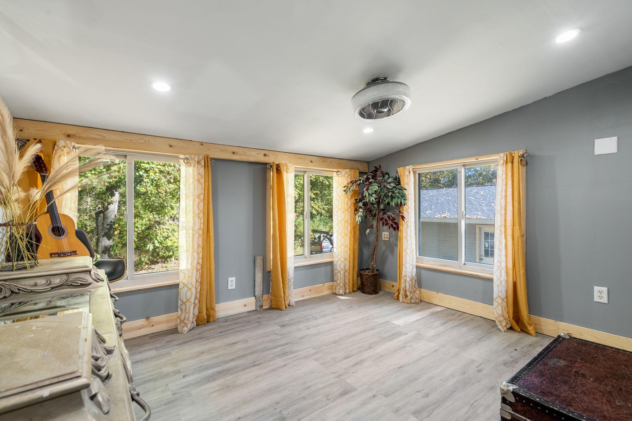 A bright, versatile room surrounded by windows, ready to become an office, sitting room, hobby space or whatever fits your needs.