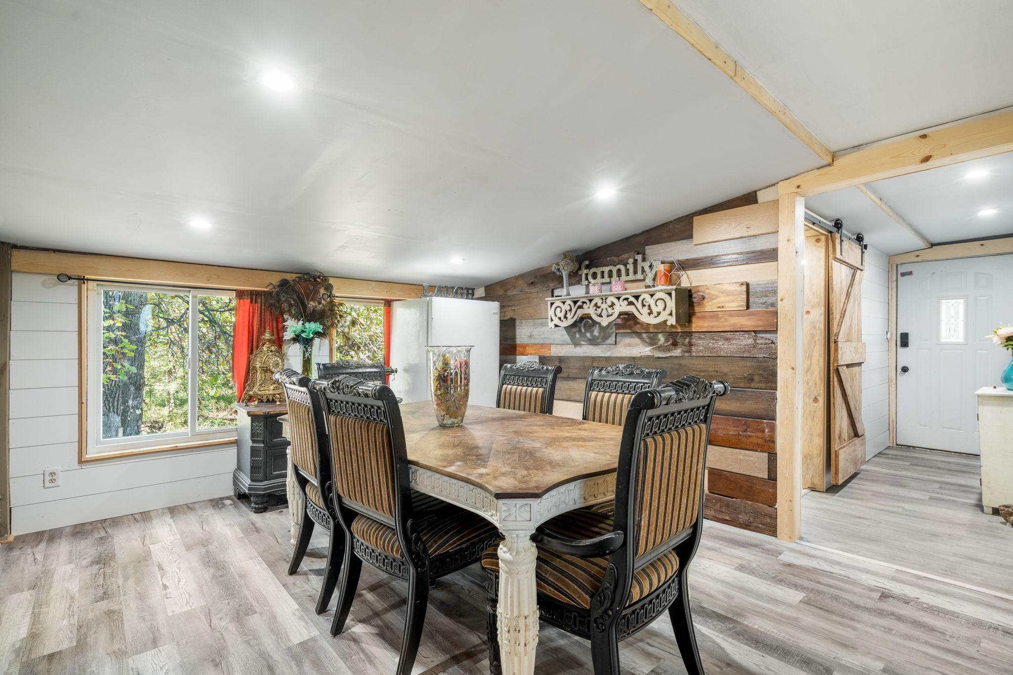 A spacious dining area with a beautiful wood accent wall and plenty of room for everyday meals or a full house around the table.