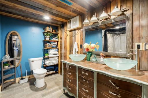 A truly unique updated bath featuring warm wood finishes, dual vessel sinks and a furniture-style vanity.