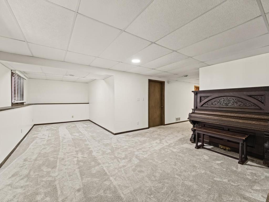 Another view of lower level family room from the fireplace. Furnace room/laundry room behind closed door.