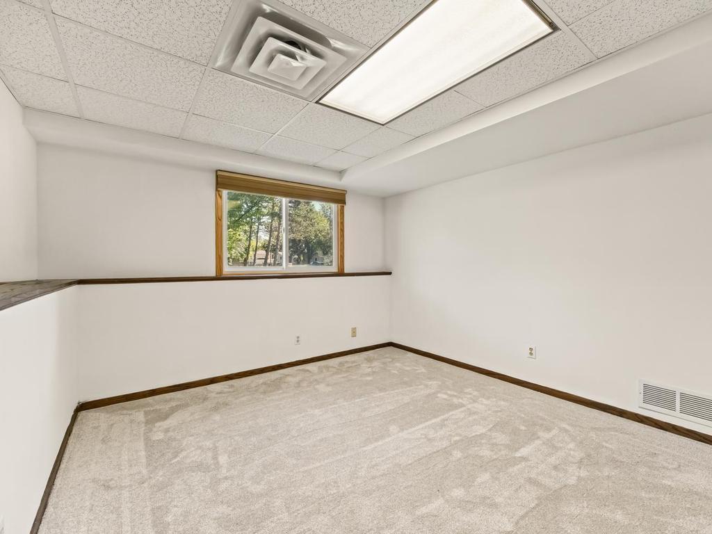 4th bedroom in lower level with New Anderson windows installed in 2022 and New Carpet.
