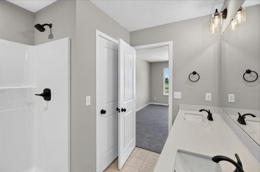 PHOTO OF A DIFFERENT HOME WITH SIMILAR PLAN AND FINISHES. Primary Suite Private Bathroom.