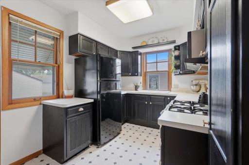 A bright, efficient kitchen offers refinished cabinetry, a gas range, new farmhouse sink and windows that bring generous natural light into the space.