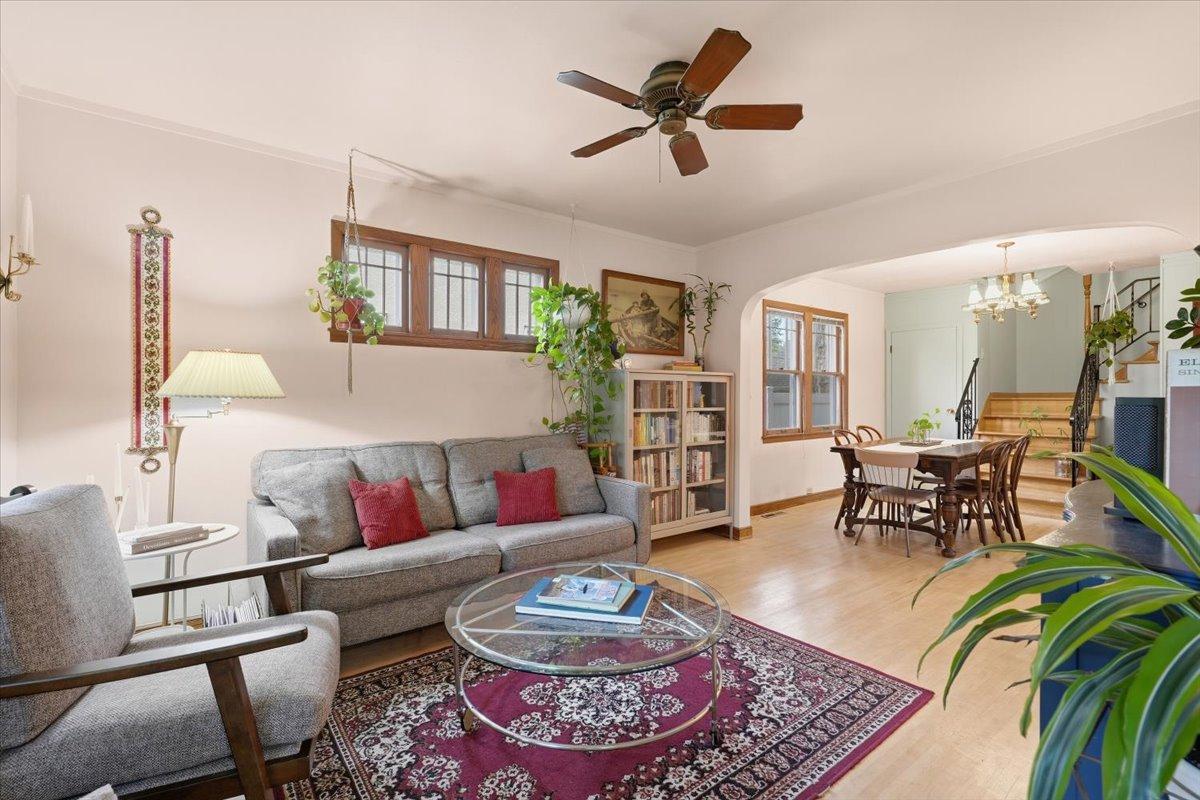 An arched opening connects the living and dining spaces, while refinished hardwood floors and original woodwork bring warmth throughout the main level.