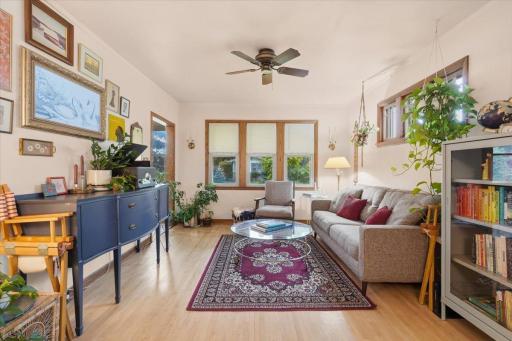 Natural light fills the living room, where refinished hardwood floors and original wood trim create an inviting place to settle in.