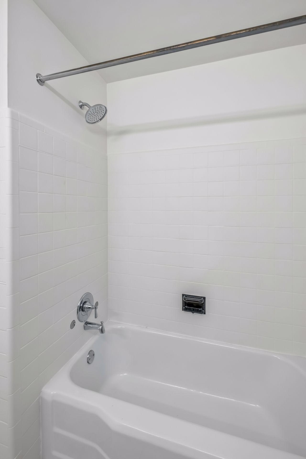 New Plumbing fixtures, lighting, vanity and window with views of backyard.