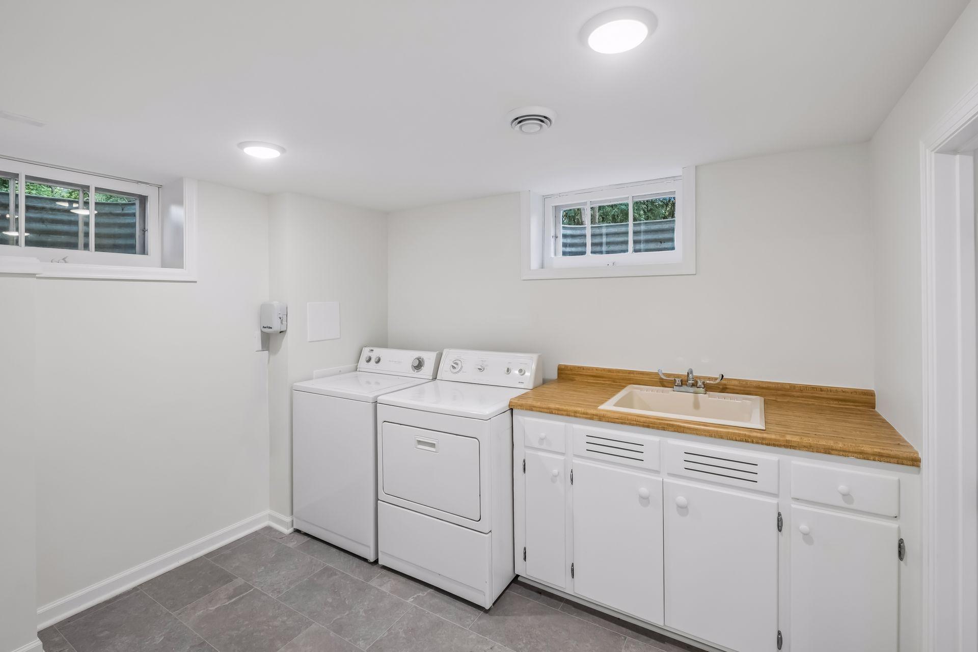 Lower level laundry room with sink and folding area.
