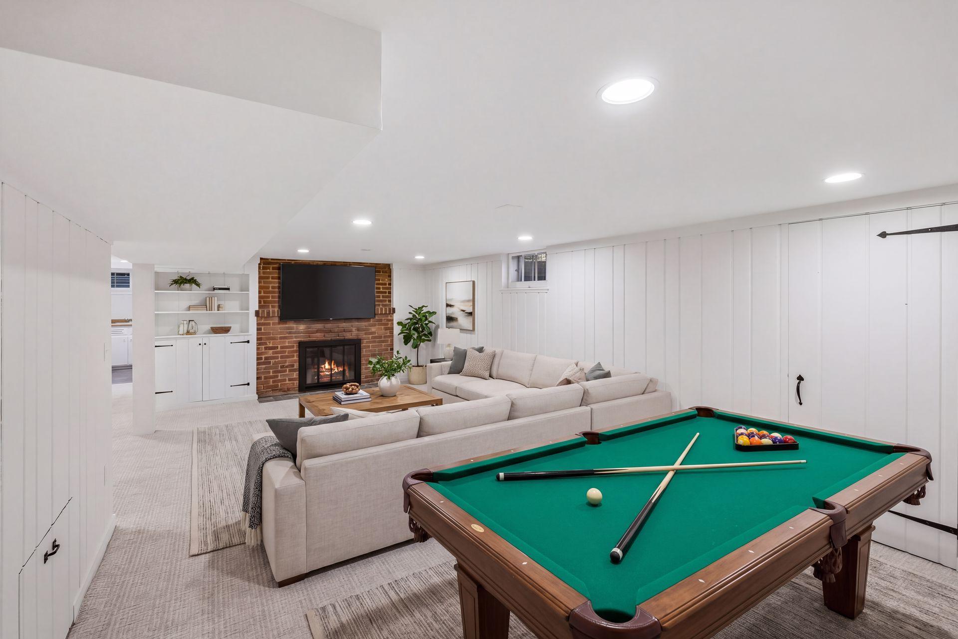 This photo is virtually staged. Lower level family room has plenty of space for play! Wood burning fireplace w pull out wood storage and more.
