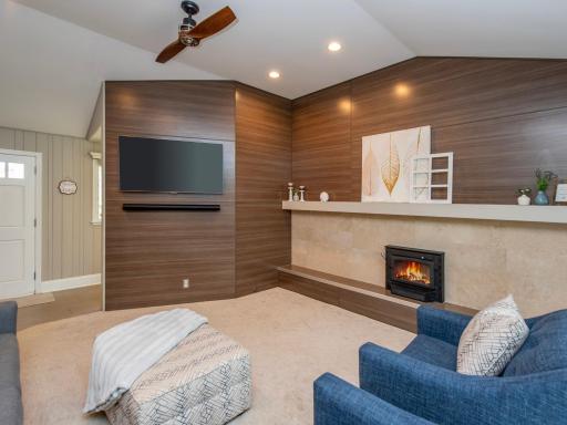 A stunning accent wall is complemented by a wood-burning fireplace with a beautiful tile surround as you enter the home.