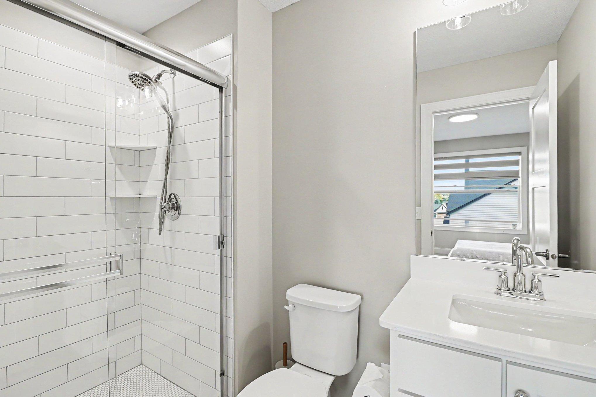 2nd bedroom ensuite with custom tiled shower.