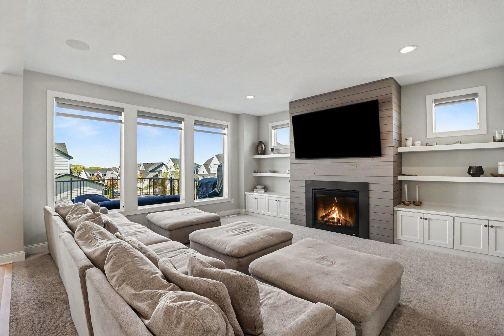 Main floor family room with walls of windows, custom cabinetry, and a gas fireplace.