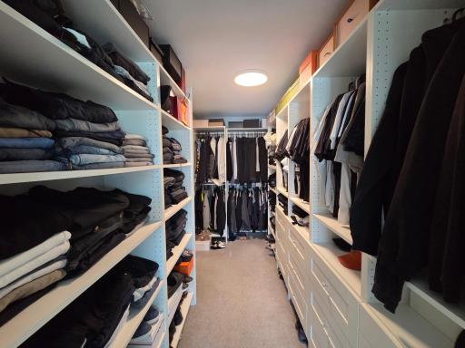 A large primary closet with its own access to the laundry room.