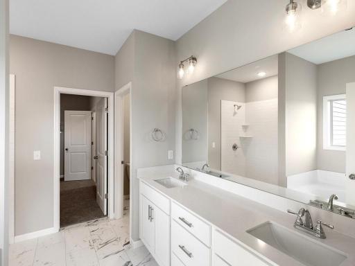 PHOTO OF A DIFFERENT HOME WITH SIMILAR PLAN. FINISHES MAY VARY. Primary Suite Deluxe Bath.