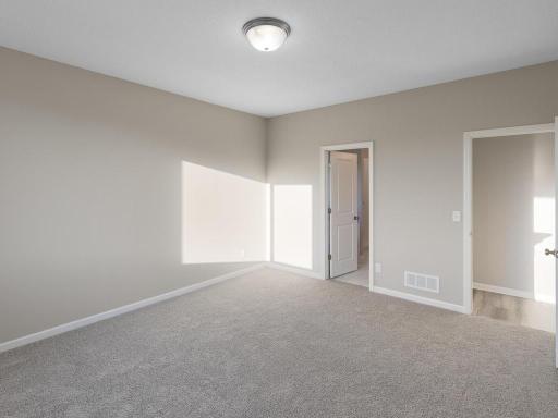 PHOTO OF A DIFFERENT HOME WITH SIMILAR PLAN. FINISHES MAY VARY. Primary Suite.