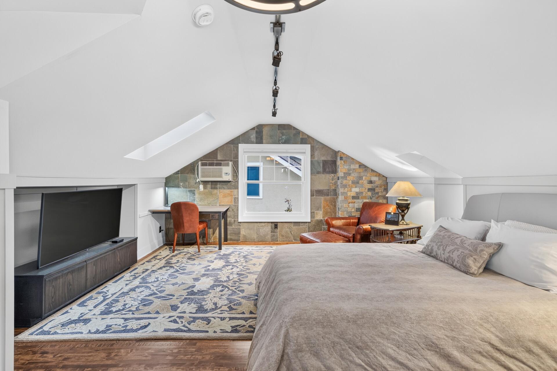 Spacious primary bedroom with hardwood floors and charming architectural details.