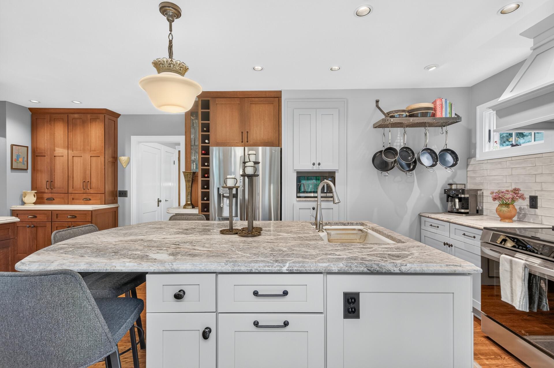 Expanded kitchen with marble countertops and abundant cabinetry.