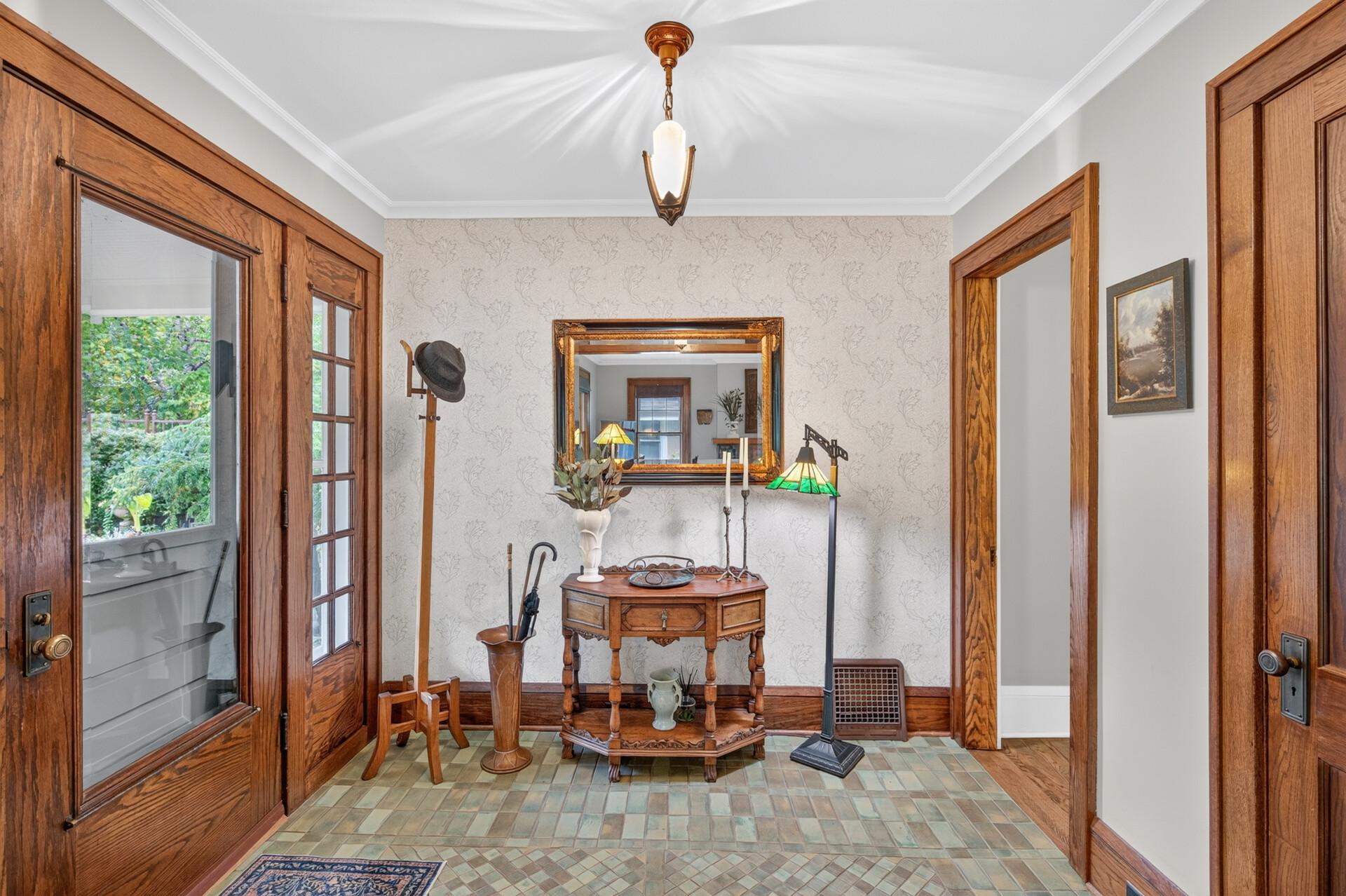 Gracious foyer with warm woodwork and vintage-inspired tile.