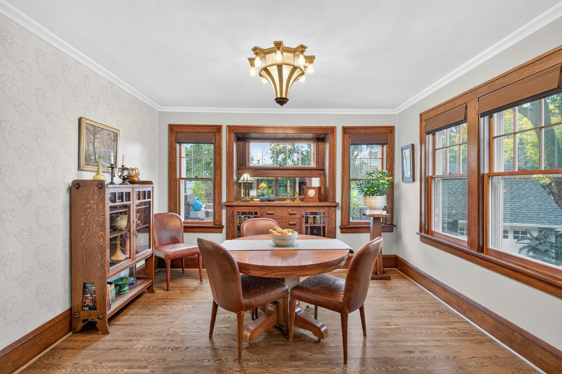 Generous dining room with built-in hutch and surrounded by windows and natural light.