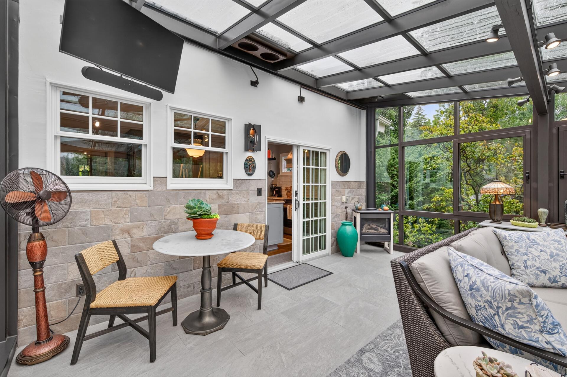 The four-season solarium features a cozy gas fireplace, wall-mounted TV and convenient sliding-door access from the kitchen.