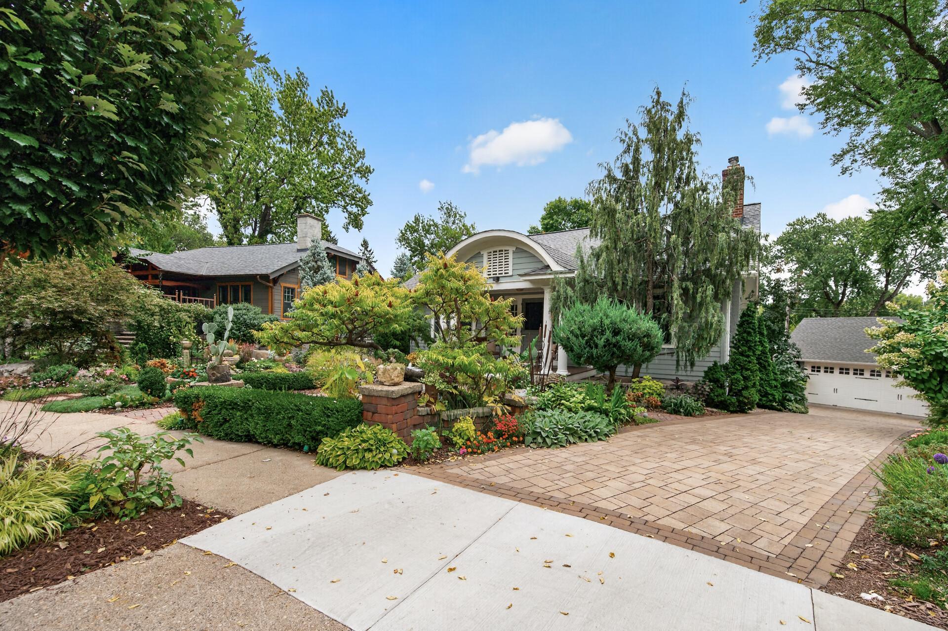 Side view of the home with paver driveway and two-car garage.