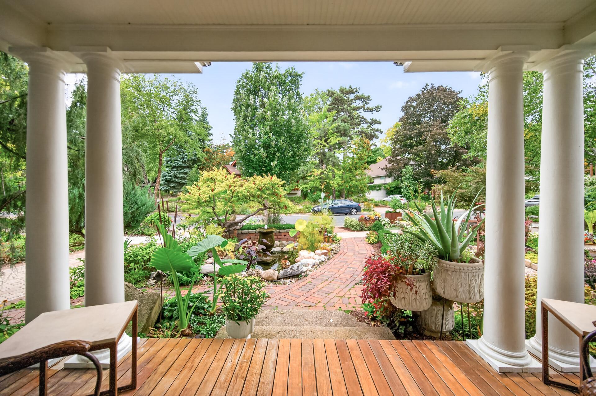 Covered front porch overlooks the garden and the paver walkway leading to the home.