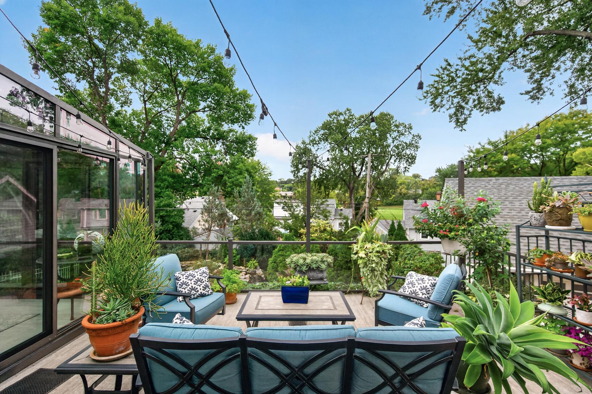 Inviting deck seating area surrounded by lush gardens and greenery.