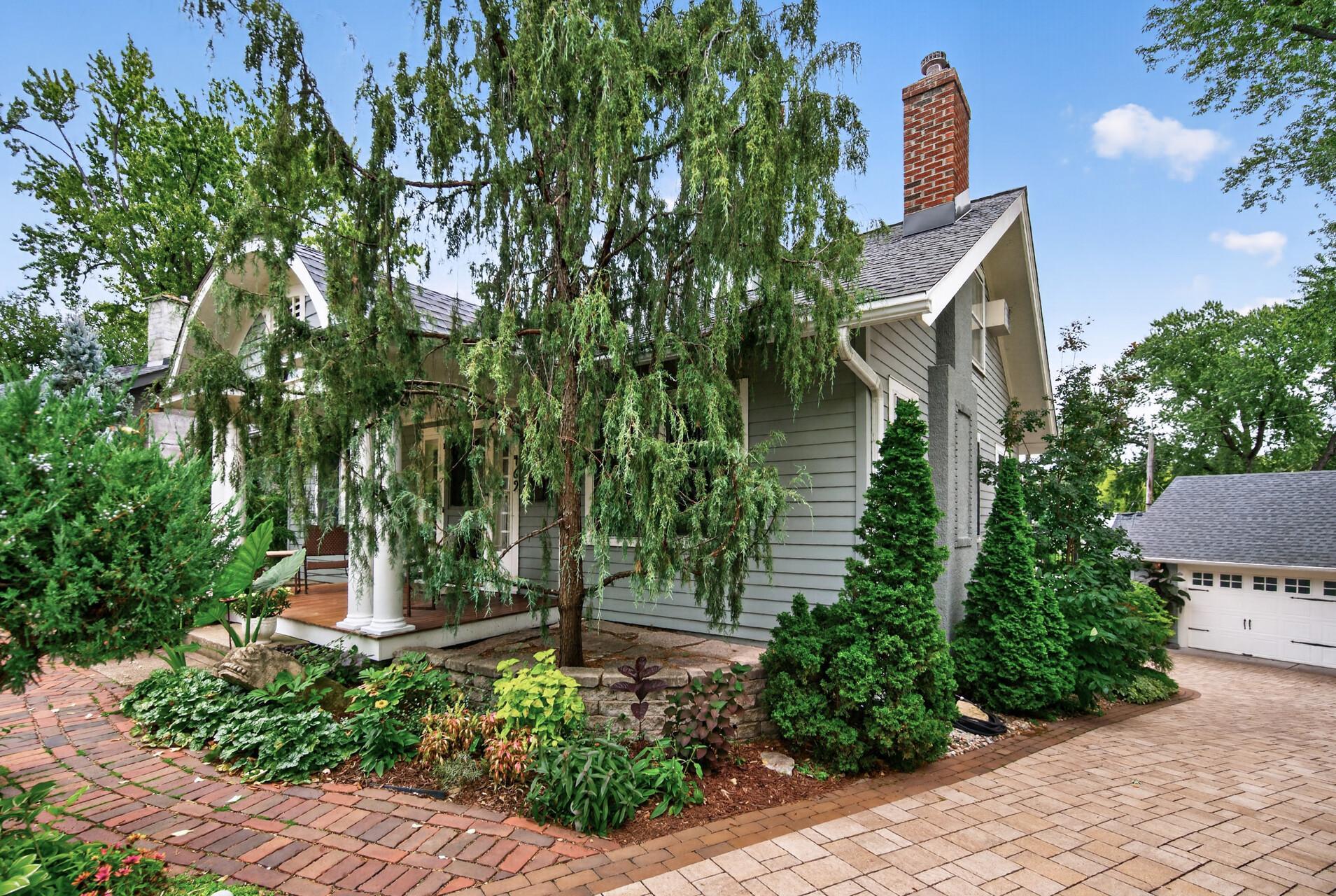Side view of the home surrounded by mature landscaping.