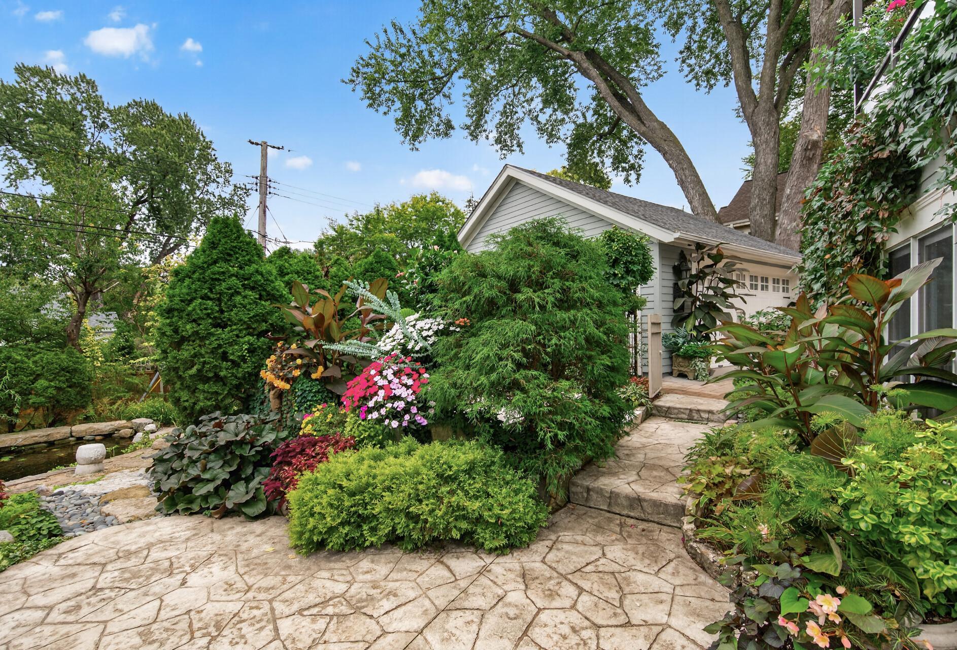 Garden pathway leads conveniently to the garage and driveway area for easy access in and out of the backyard.