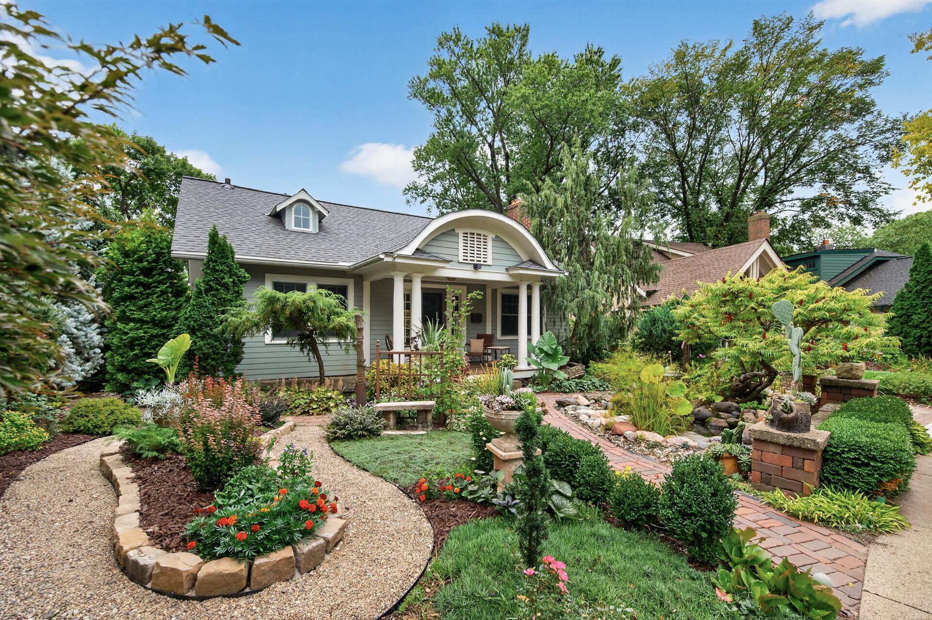 Mature trees, shrubs and perennial plantings frame the home.