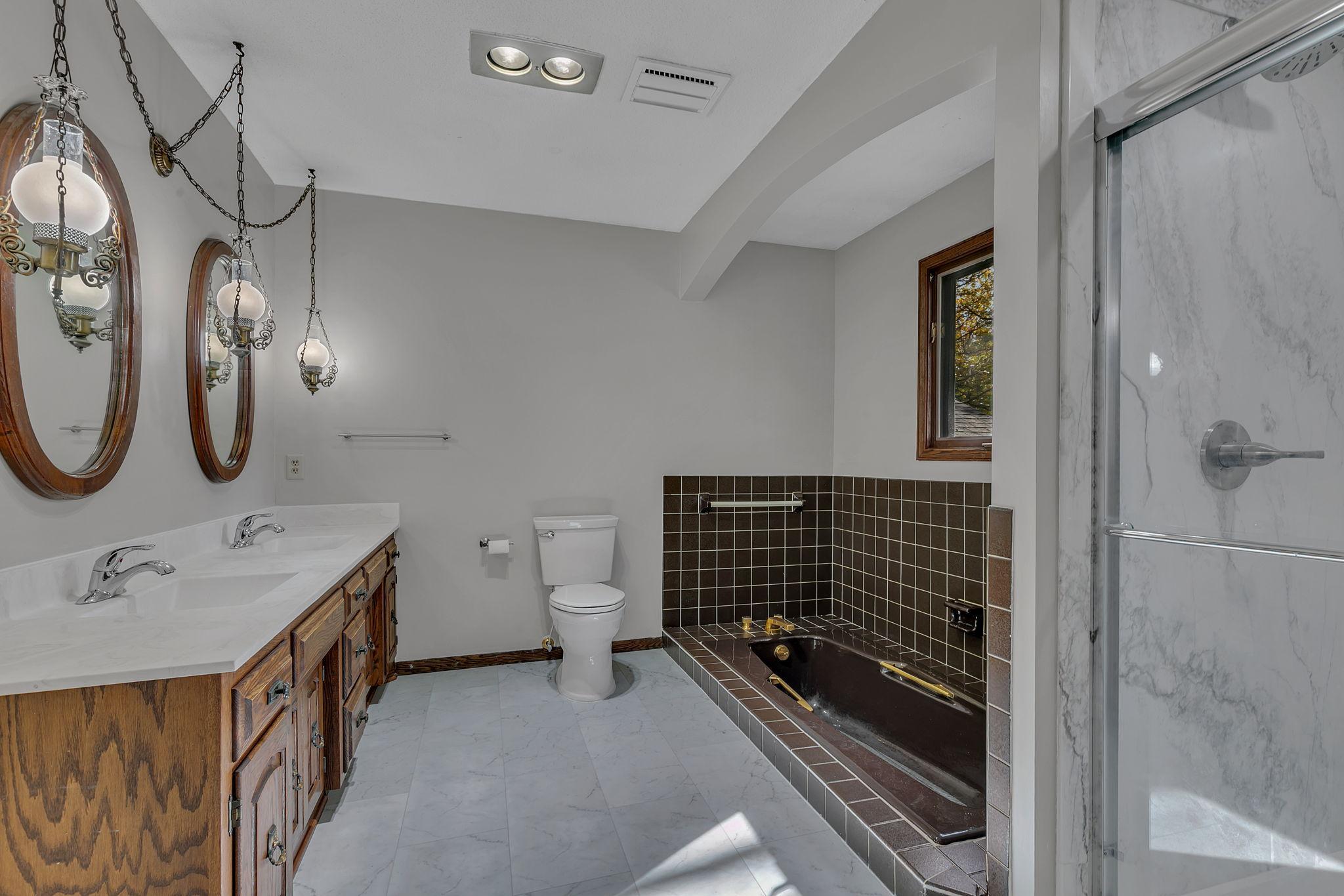 Sunken tub with separate shower along with an updated double vanity top in the private ensuite