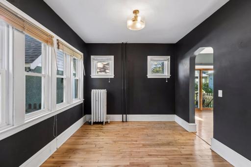 Four windows bring plenty of natural light to the formal dining space, where hardwood floors and stylish overhead lighting add warmth and character.