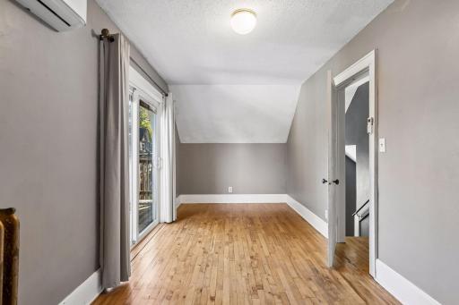 Bedroom with a balcony? Yes, please! The second upper level bedroom features hardwood floors and overhead lighting. Sip morning coffee, read a book and relax or enjoy the weather on the private balcony through the sliding doors.