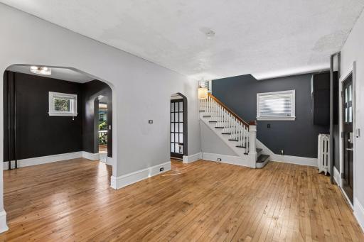 This view gives a great look at the main level flow, with the living room opening into the dining space and stairs leading to the upper level bedrooms.