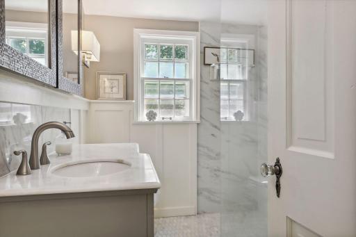Stunning upper-level bathroom with glass walk-in shower.