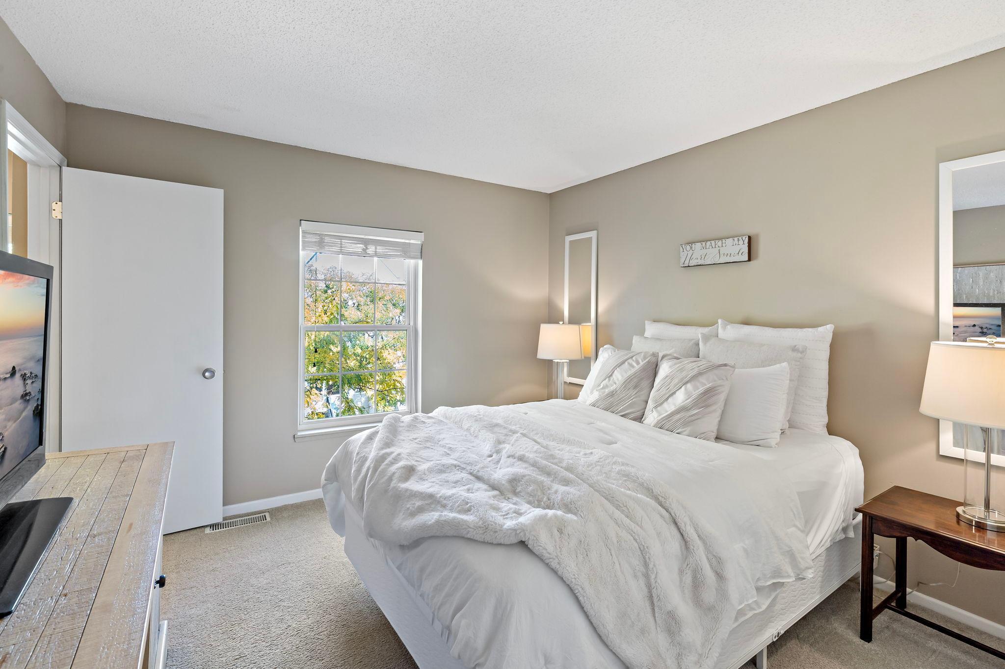 A second view highlights the bedroom’s window providing plenty of natural light and enough space for a full bedroom furniture arrangement.