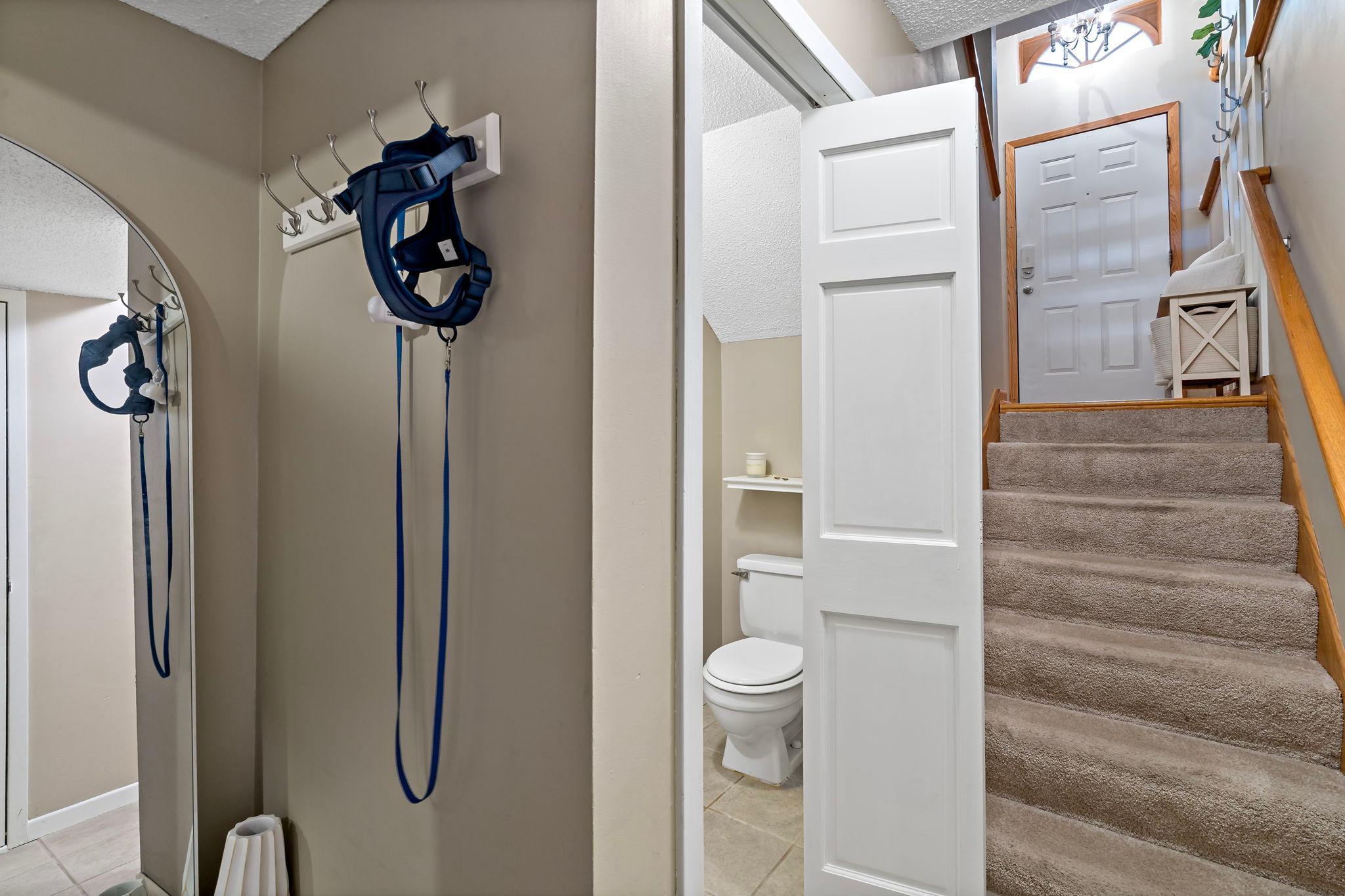 Coming in from the attached garage, this convenient lower landing provides a practical transition into the home with easy access to the utility room and half bathroom before heading upstairs to the main living areas.