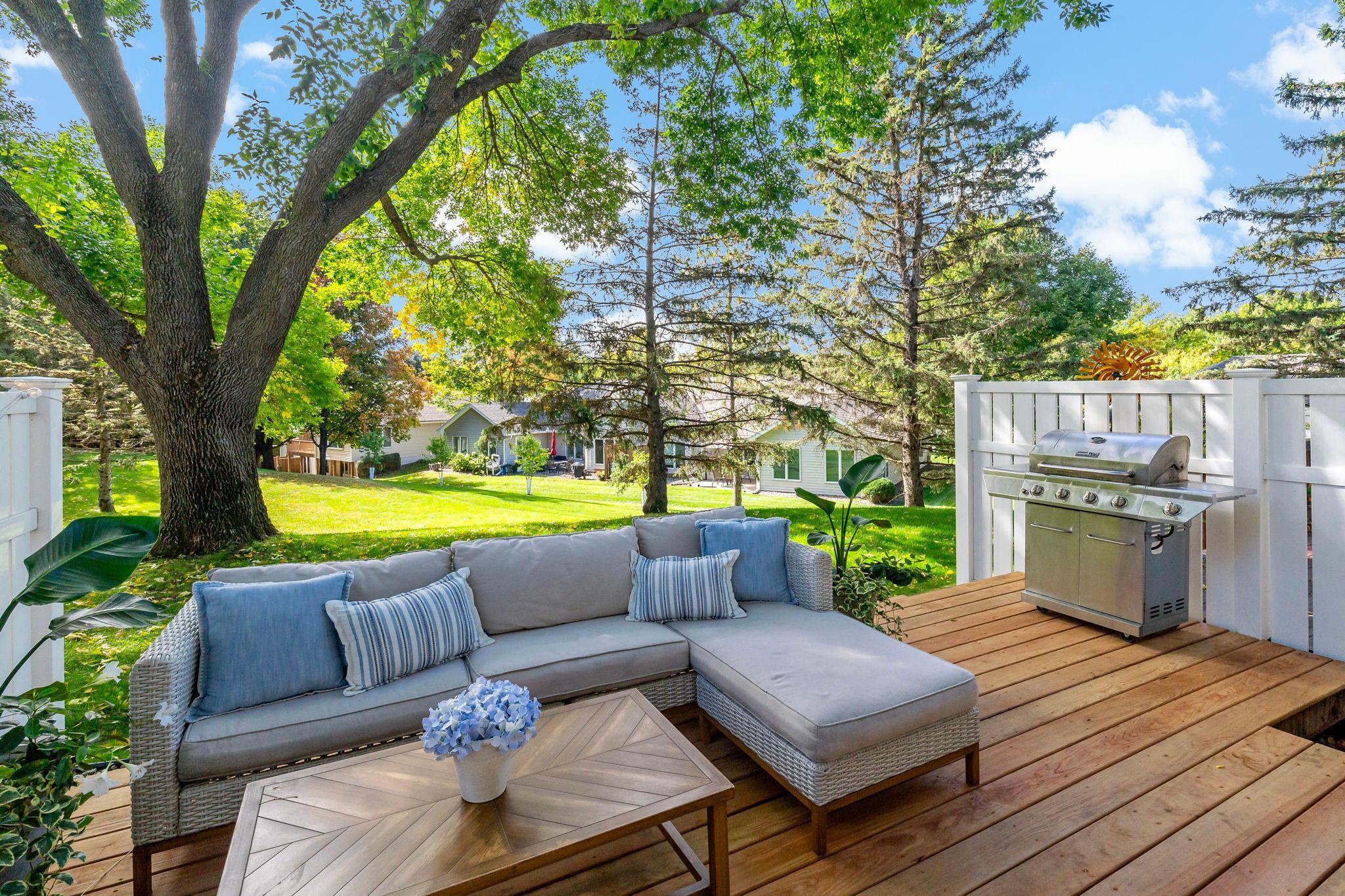 The new deck overlooks a beautiful shared green space framed by mature trees, creating a peaceful backdrop for relaxing, dining or entertaining outdoors.