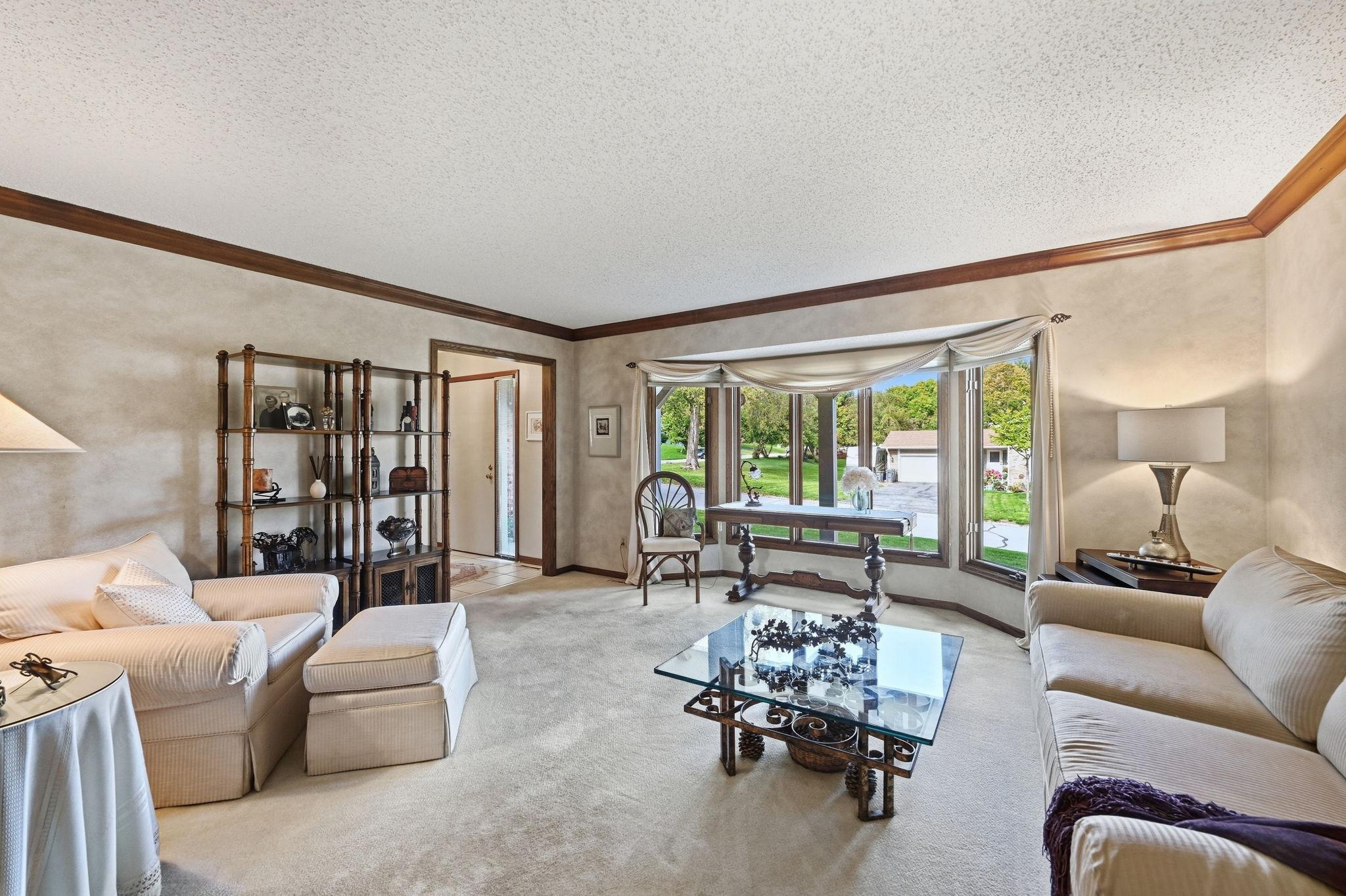 A full view of the living room showcasing the bayed, window which creates a light and bright room