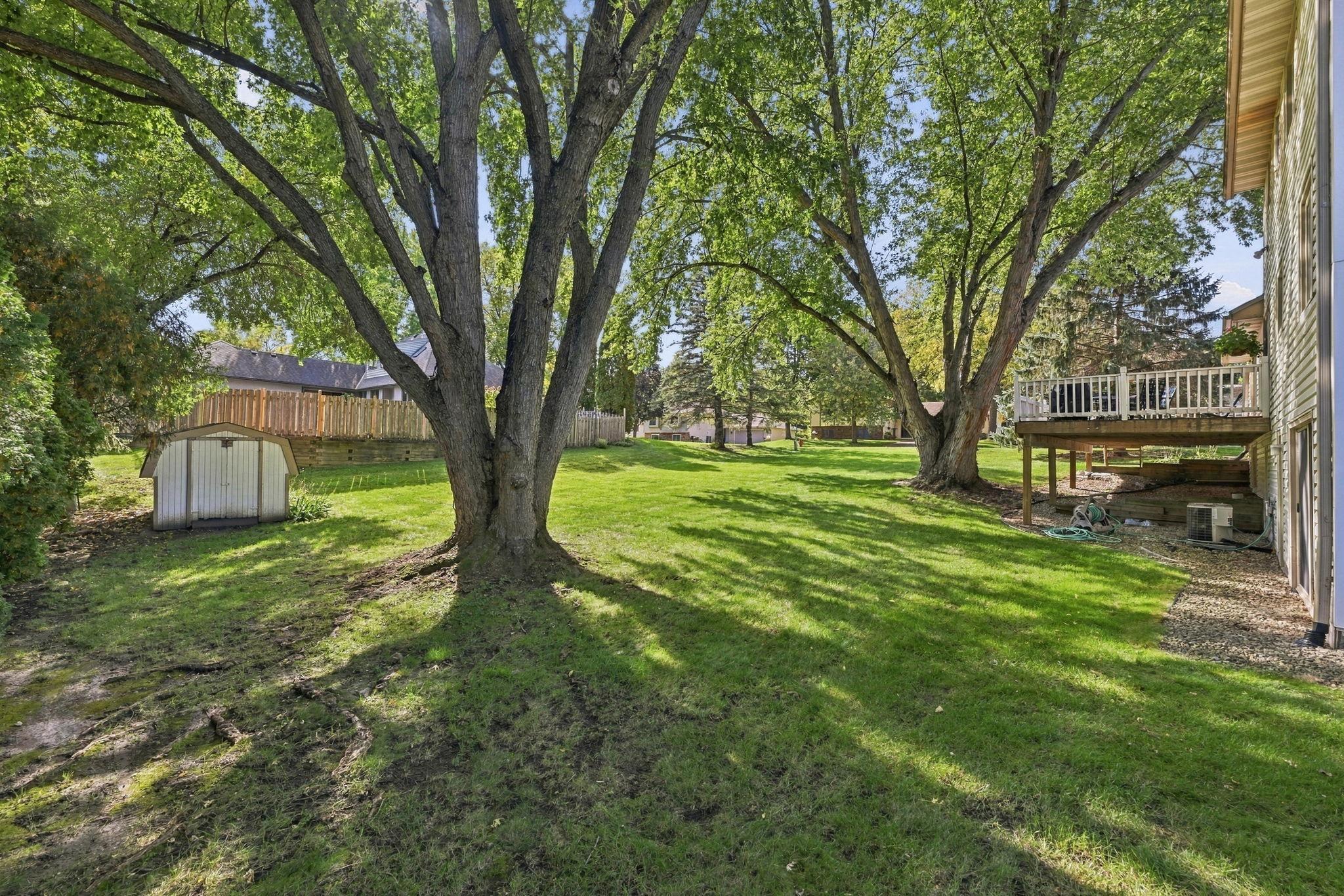 View of the shed used for storage of lawn mower, snow blower, etc. The serene back yard features a view of the large deck