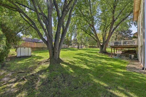 View of the shed used for storage of lawn mower, snow blower, etc. The serene back yard features a view of the large deck