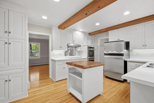 Bright and beautifully designed kitchen featuring ample cabinetry, stainless steel appliances, double ovens, and abundant prep space