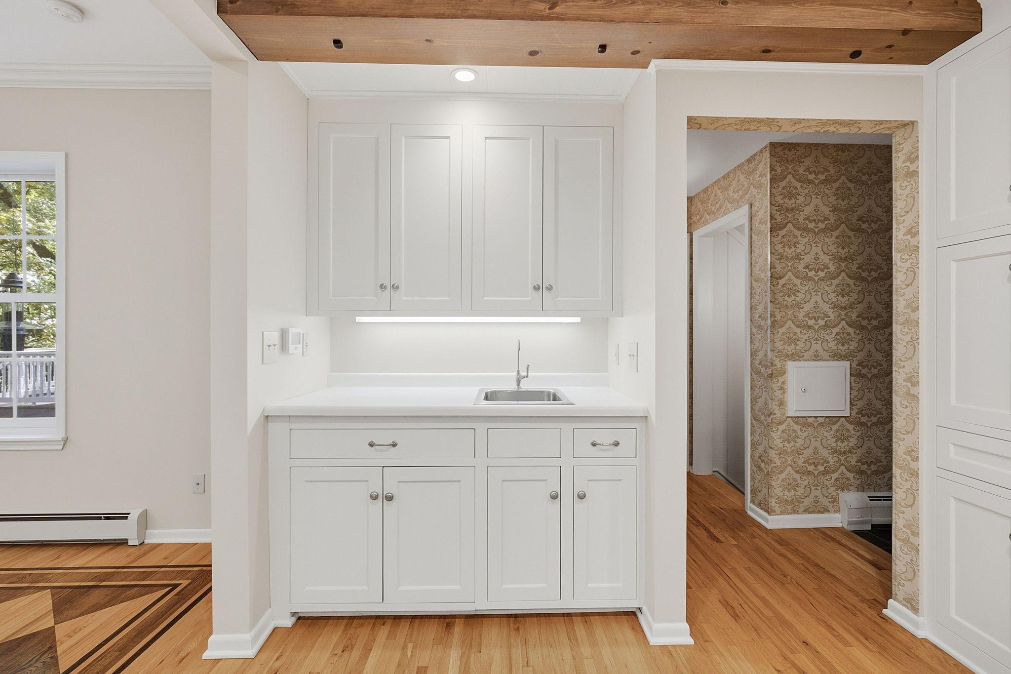Additional prep space off to the side of the kitchen with a sink provides space for a morning coffee bar area or evening libations