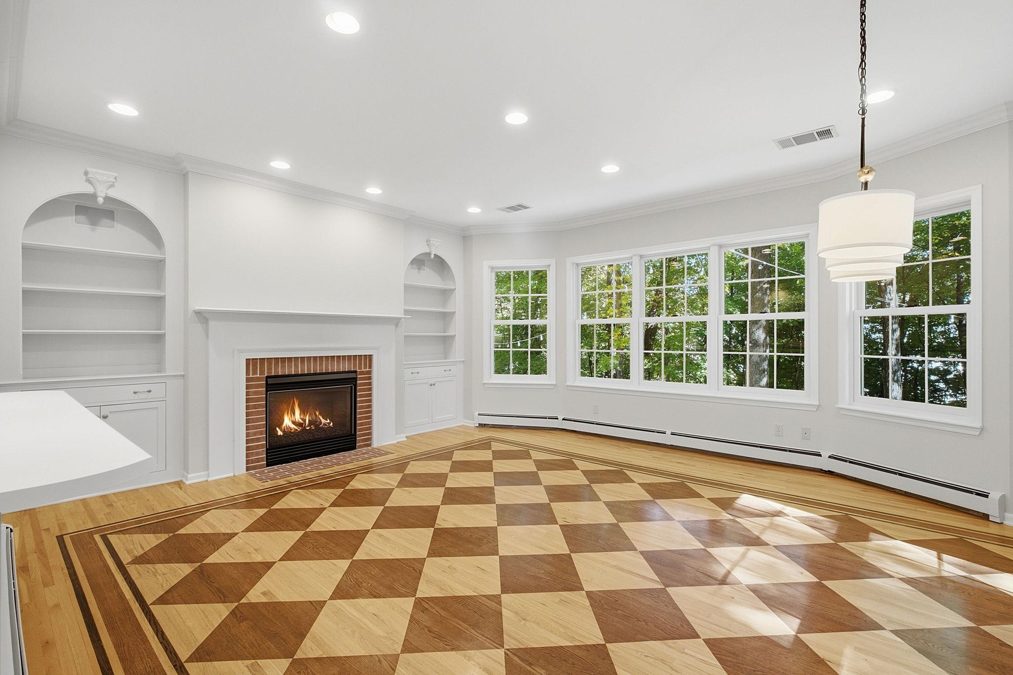 Step over into the family room with checked wood floors, gas fireplace, and stunning views of the backyard