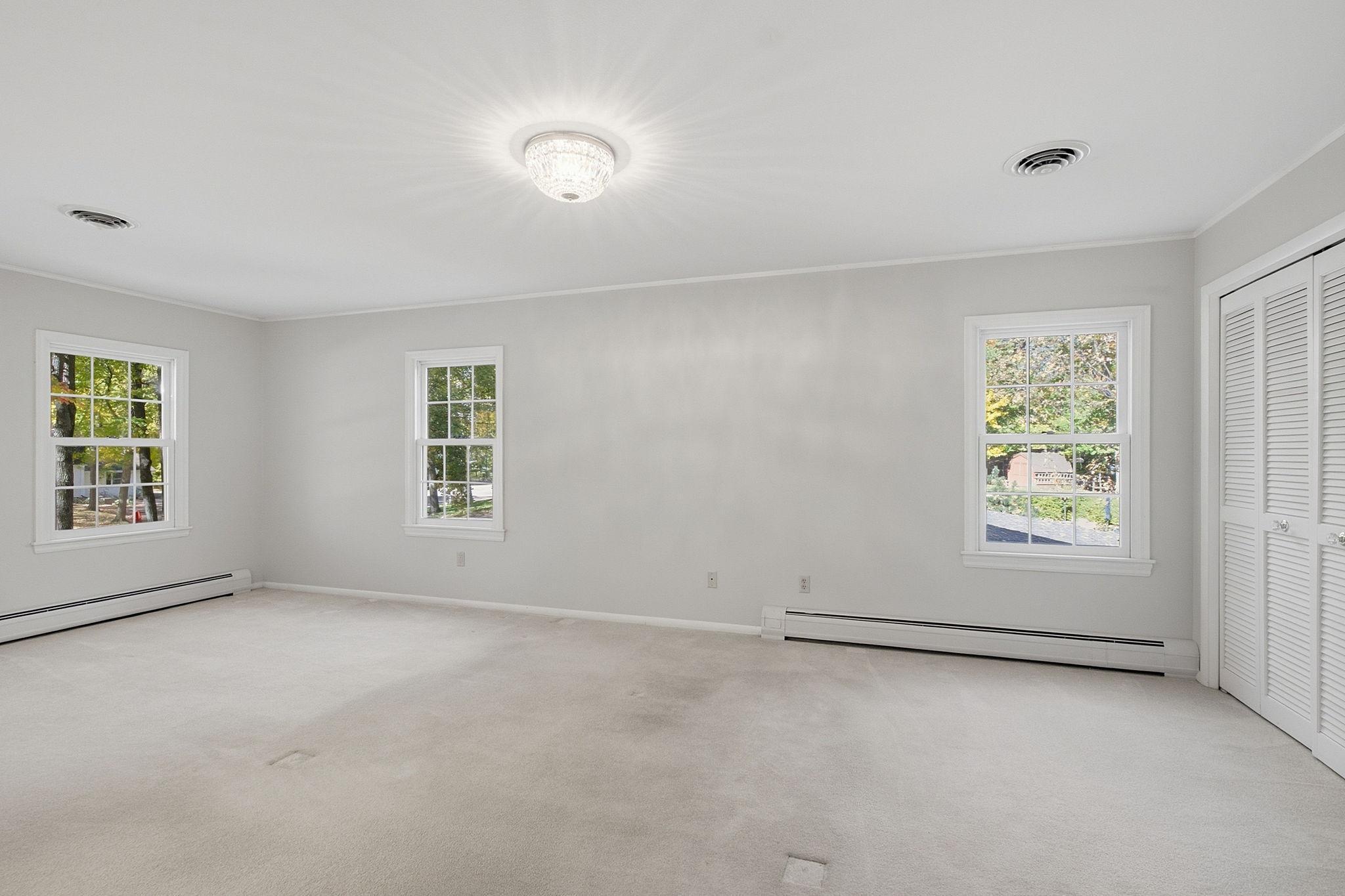 Corner primary bedroom is filled with natural light