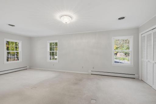 Corner primary bedroom is filled with natural light