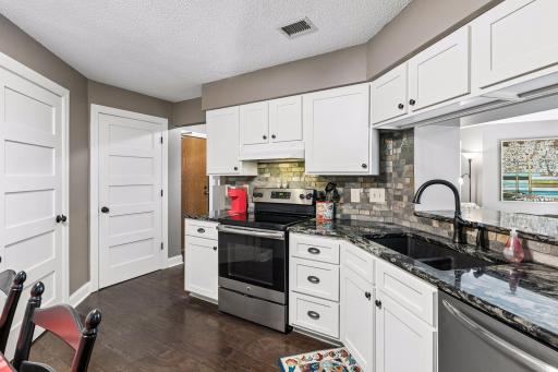 The kitchen has SS appliances, granite counters, tile backsplash and updated cabinets.