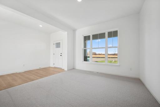 Filled with natural light, this versatile space is perfect for a home office, reading nook, or sitting area. The open layout and warm touches make it both functional and inviting. Home under construction, photo of similar home, selections vary.