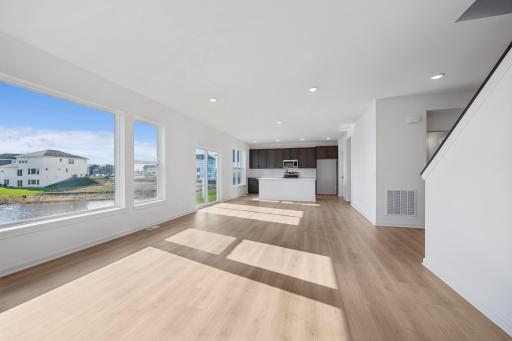 This stylish kitchen features rich cabinetry, quartz countertops, stainless steel appliances, and a large island-perfect for cooking, dining, or entertaining. Home under construction, photo of similar home, selections vary.
