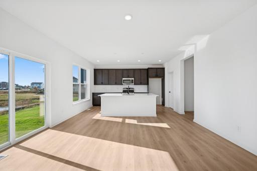 This stylish kitchen features rich cabinetry, quartz countertops, stainless steel appliances, and a large island-perfect for cooking, dining, or entertaining. Home under construction, photo of similar home, selections vary.