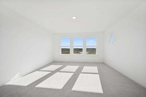 Bright and spacious with large windows and peaceful views, this primary suite offers a relaxing escape. Home under construction, photo of similar home, selections vary.